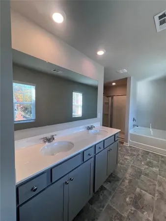 a bathroom with a tub sink and mirror