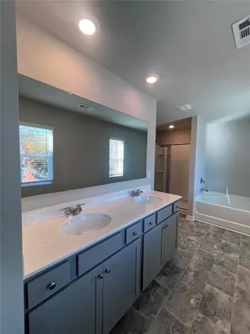 a bathroom with a tub sink and mirror