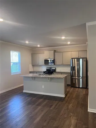 a living room with stainless steel appliances kitchen island granite countertop a refrigerator stove and a window