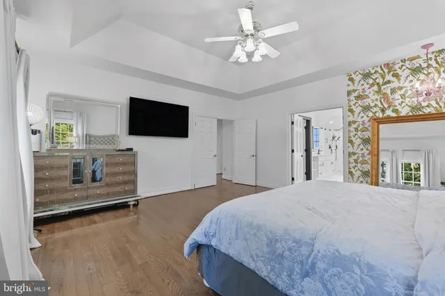 a spacious bedroom with a bed and a flat screen tv