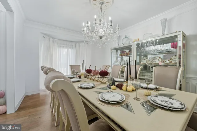 a dining room with furniture a chandelier and wooden floor