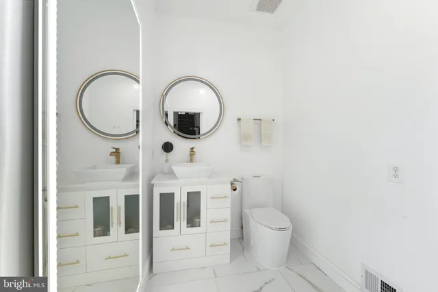 a bathroom with a toilet a sink and a mirror