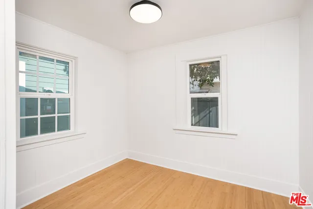 a large white kitchen with stainless steel appliances granite countertop a stove a sink a refrigerator and white cabinets