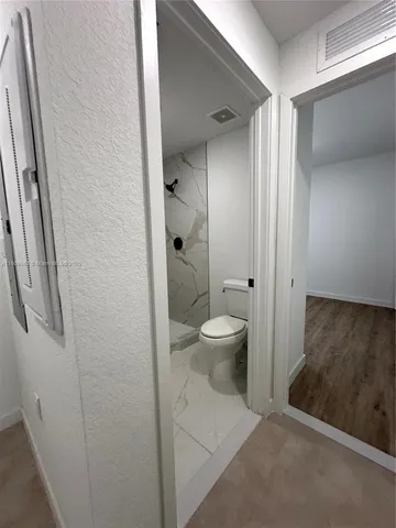 a bathroom with a toilet and a shower