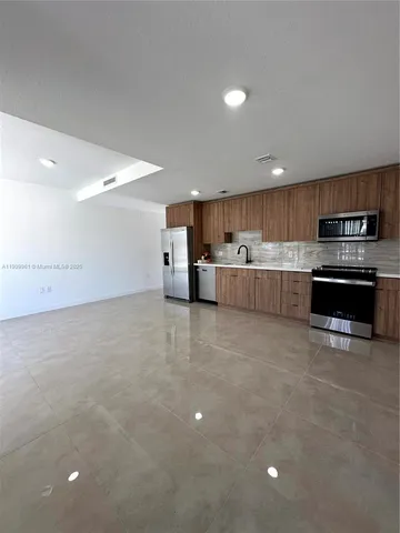 a kitchen with stainless steel appliances a refrigerator sink and microwave