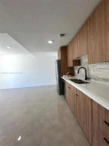 a kitchen with granite countertop a sink stove and cabinets