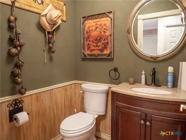 a bathroom with a toilet a sink and mirror