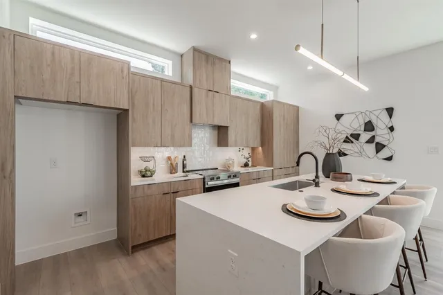 a kitchen with a sink a stove and chairs
