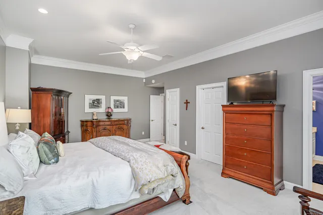 a bedroom with a bed and a flat tv screen on dresser