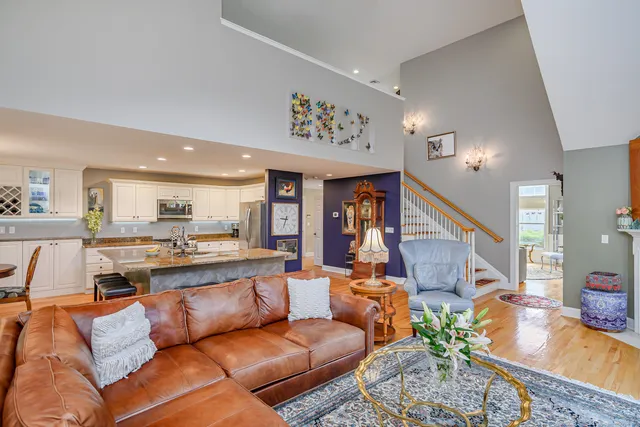a living room with furniture kitchen view and a large window