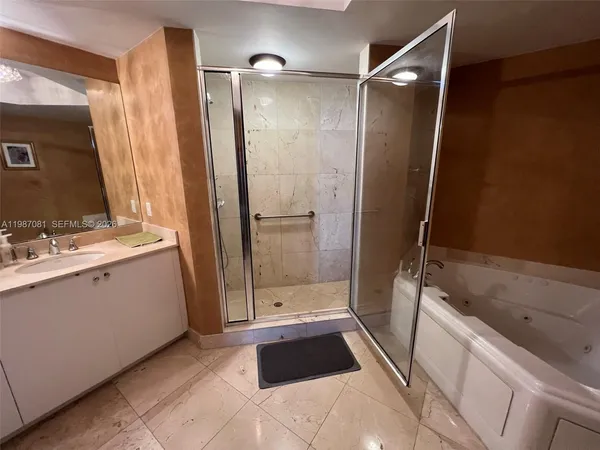 a bathroom with a sink a toilet a mirror and shower