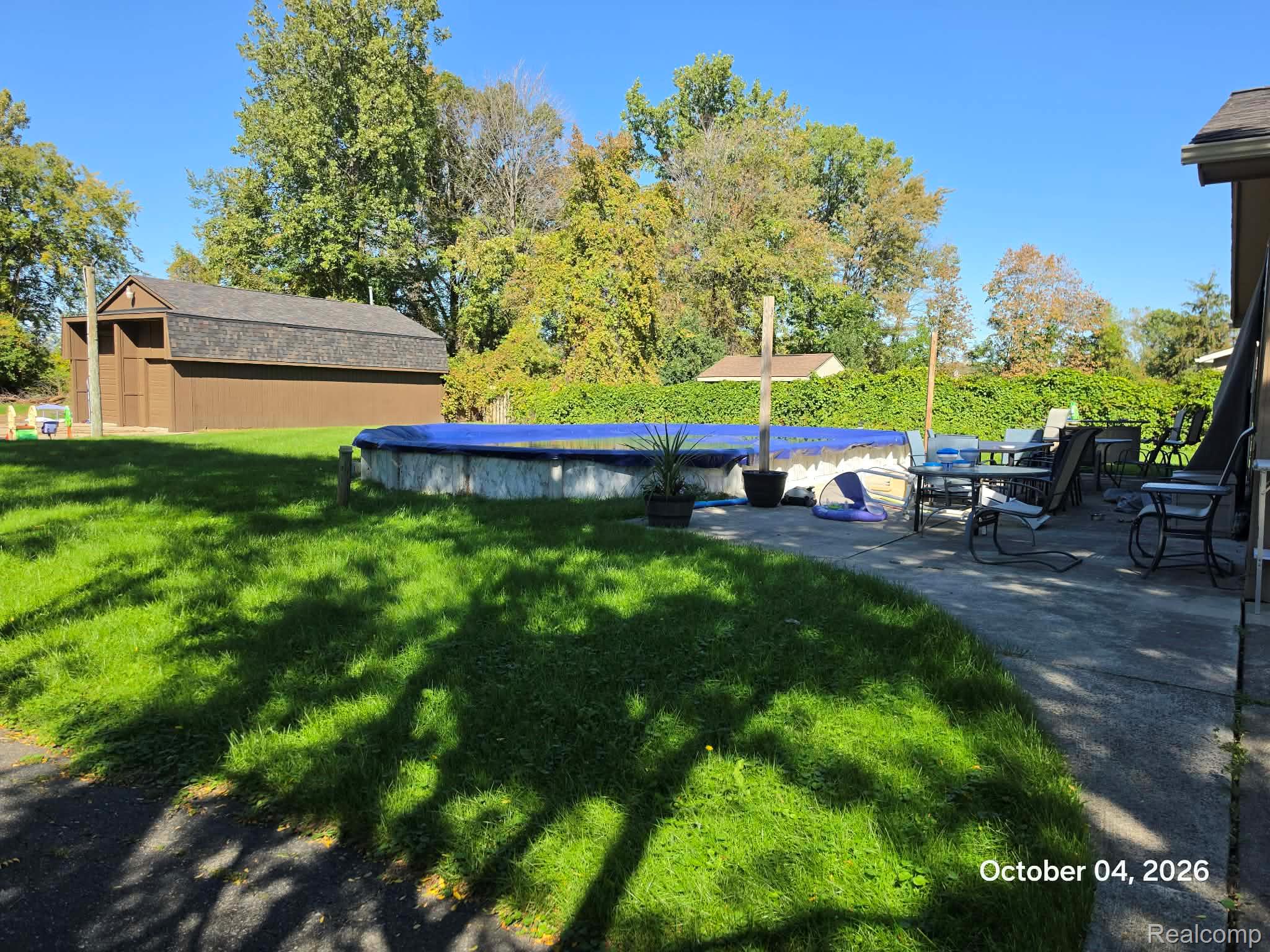 34781 Union Lake Road Clinton Township, MI 48035 - Photo 29 of 38 Expansive lawn, concrete patio, above-ground swimming pool, and detached storage shed