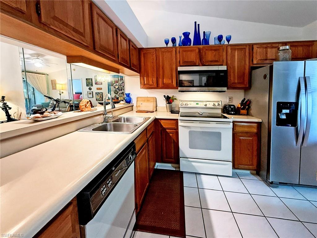 2005 Pine Isle Lane, Unit 2005 Naples, FL 34112 - Photo 7 of 23 Kitchen with solid oak cabinets, tile floor and high ceiling.