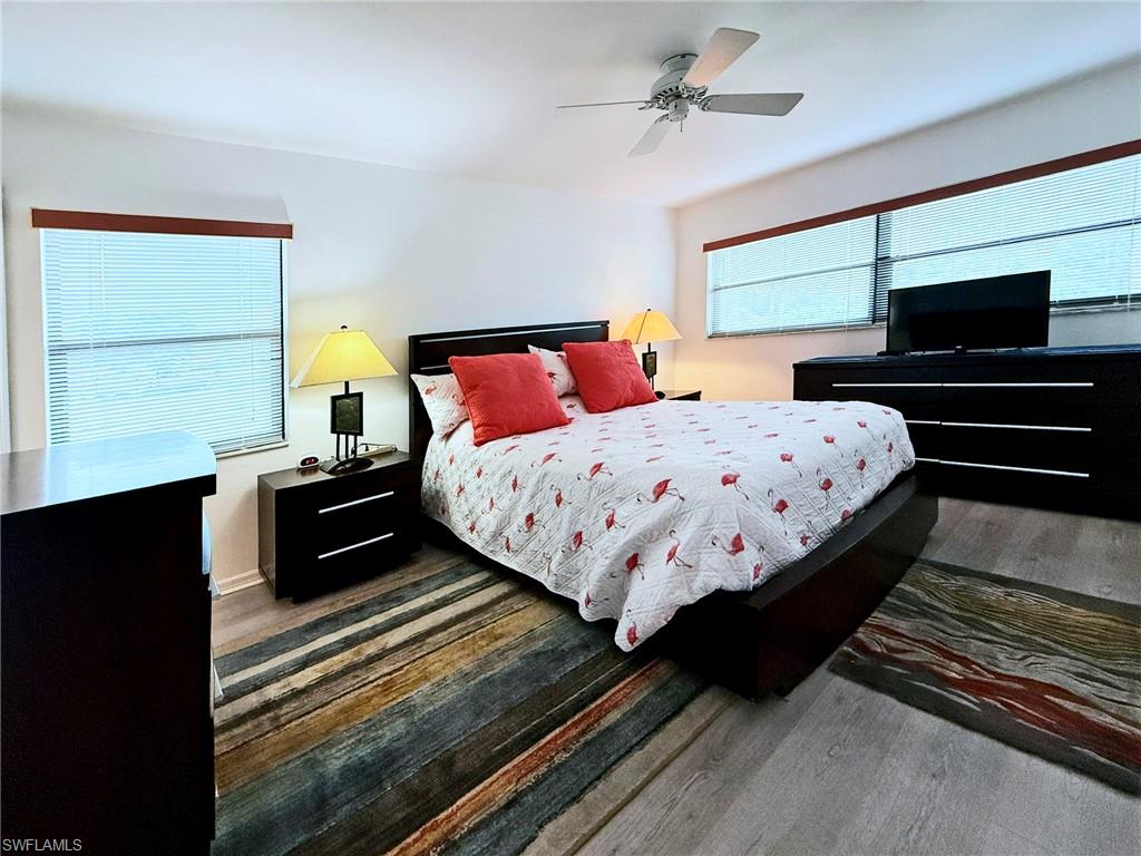 2005 Pine Isle Lane, Unit 2005 Naples, FL 34112 - Photo 8 of 23 Owner's Bedroom featuring ceiling fan, wood-type flooring and extra windows.