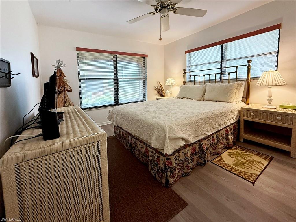 2005 Pine Isle Lane, Unit 2005 Naples, FL 34112 - Photo 10 of 23 Guest Bedroom with wood finished floor. a ceiling fan and extra windows.