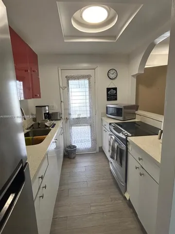a kitchen with granite countertop a sink stove and cabinets