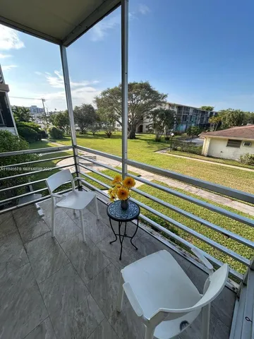 a view of a porch with furniture and a yard