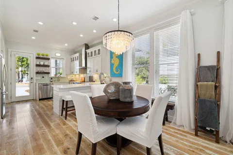 a living room with stainless steel appliances furniture a rug and a kitchen view