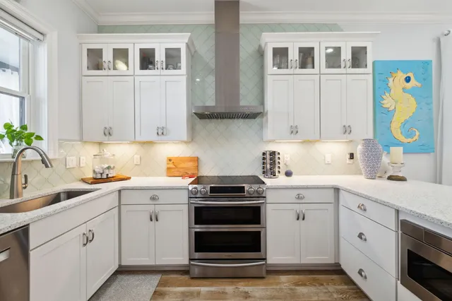 a spacious bedroom with a bed a dresser and chandelier