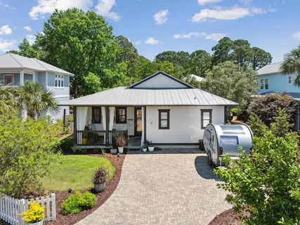 a front view of a house with a yard and potted plants