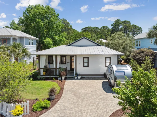 a front view of a house with a yard and potted plants