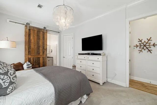 a bedroom with a large bed and a flat tv screen