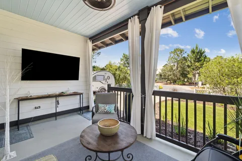 a living room with patio furniture and a potted plant