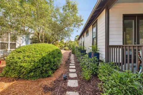 a front view of a house with a yard and potted plants