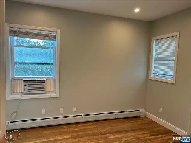 a view of a room with wooden floor and windows