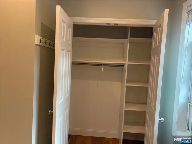 a view of walk in closet with empty racks