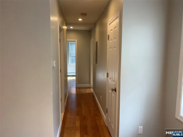 a view of hallway with wooden floor