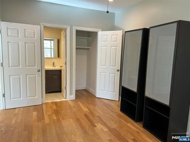 a view of hallway with wooden floor and cabinet