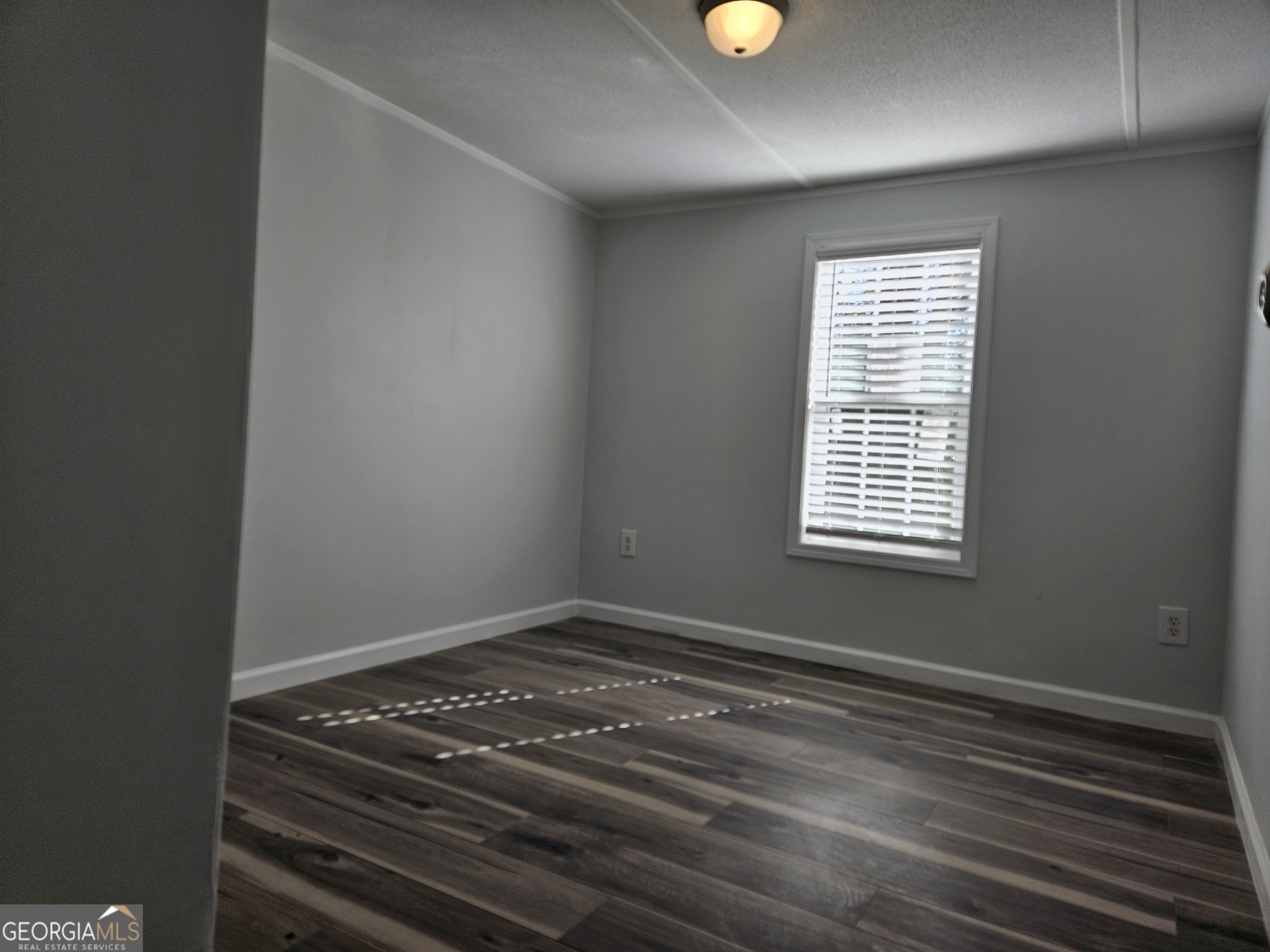 150 Back Street Metter, GA 30439 - Photo 11 of 21 a view of an empty room with wooden floor and a window