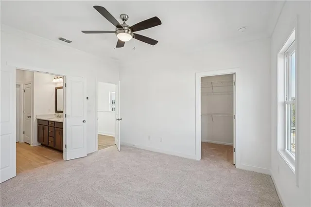 a view of a livingroom with a ceiling fan & entryway