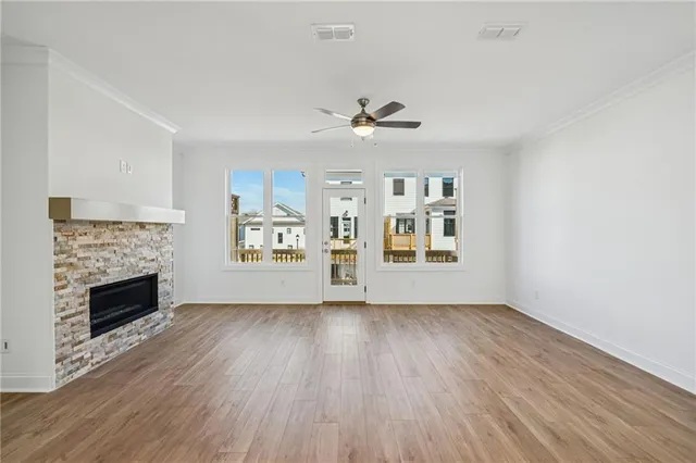 a view of an empty room with window and wooden floor