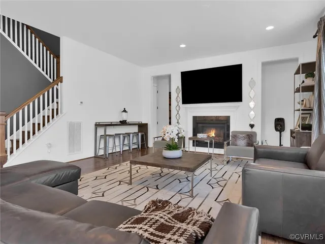 a living room with furniture a flat screen tv and a fireplace