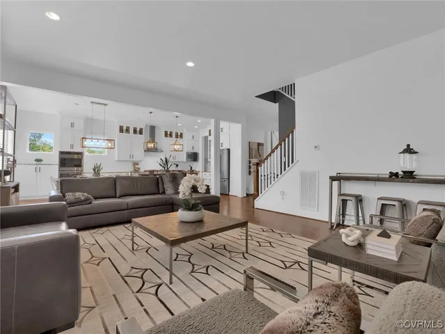 a living room with furniture and wooden floor