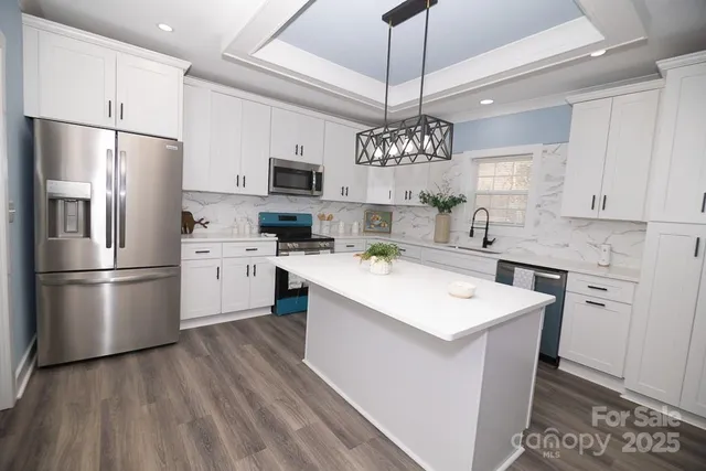 a kitchen with stainless steel appliances a sink stove refrigerator and cabinets