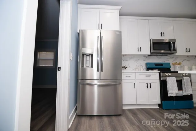 a kitchen with stainless steel appliances a refrigerator sink and microwave