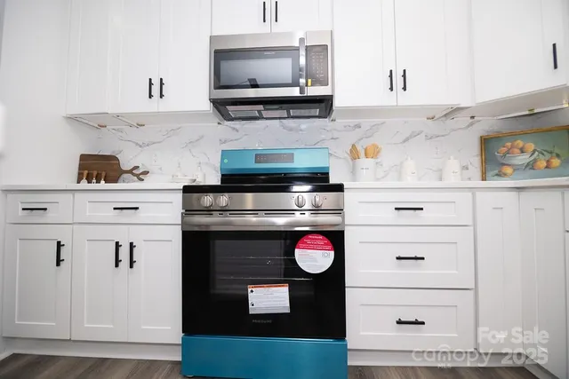 a kitchen with granite countertop a stove and cabinets