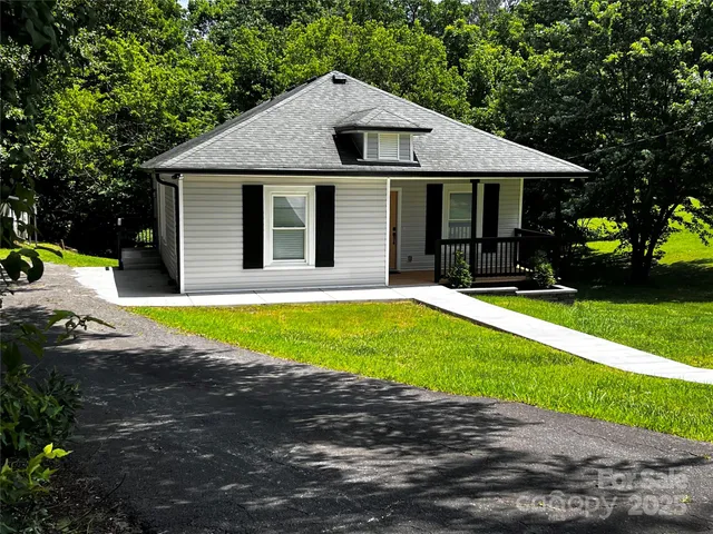 a view of a house with a yard and sitting area