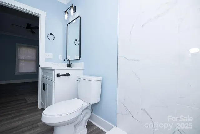 a white toilet sitting next to a bathroom sink and vanity