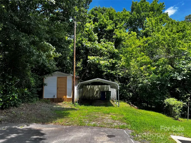 a view of a tiny house with backyard and trees