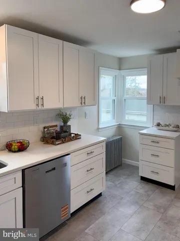 a kitchen with cabinets appliances a sink and a window