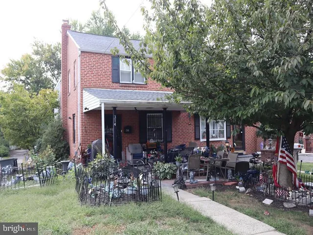 a view of house with a yard and sitting area