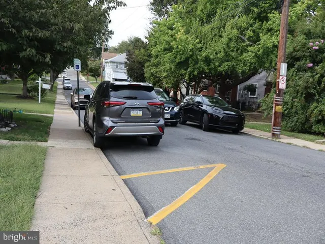a car parked in front of a house with a yard