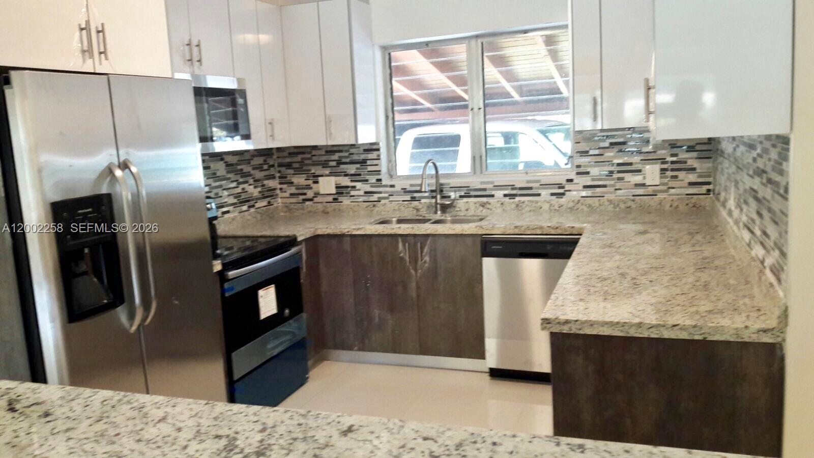 3700 Taft Street Hollywood, FL 33021 - Photo 1 of 10 a kitchen with stainless steel appliances granite countertop a sink stove and refrigerator