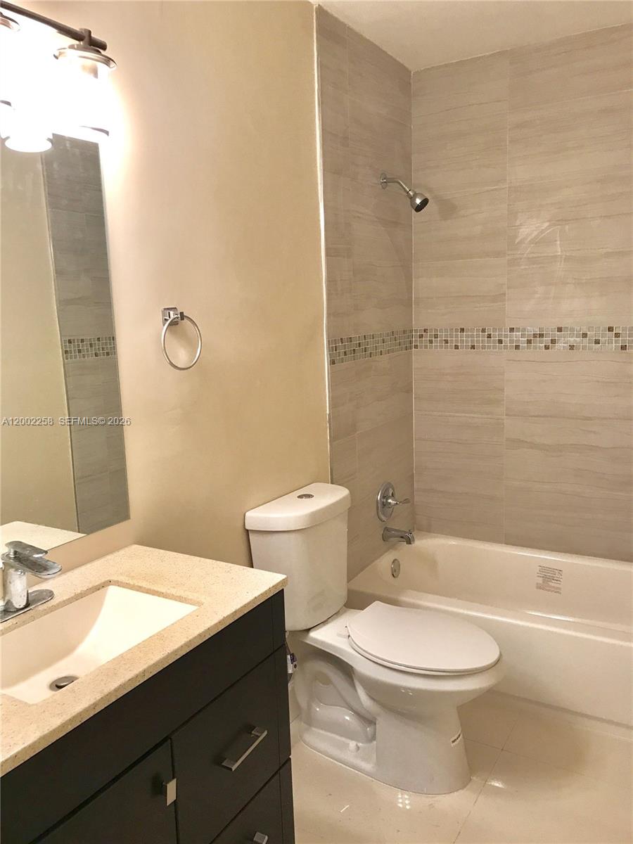 3700 Taft Street Hollywood, FL 33021 - Photo 5 of 10 a bathroom with a granite countertop toilet a sink and a bathtub