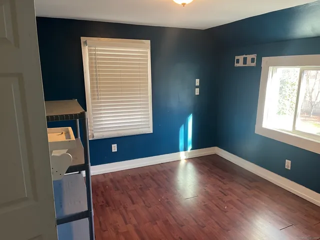 a view of empty room with wooden floor and windows
