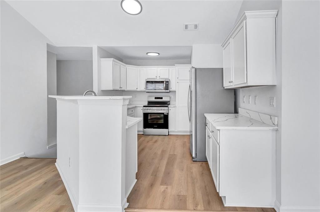 2540 Willow Grove Road, Unit 15 Acworth, GA 30101 - Photo 13 of 35 a kitchen with a refrigerator a stove top oven and white cabinets